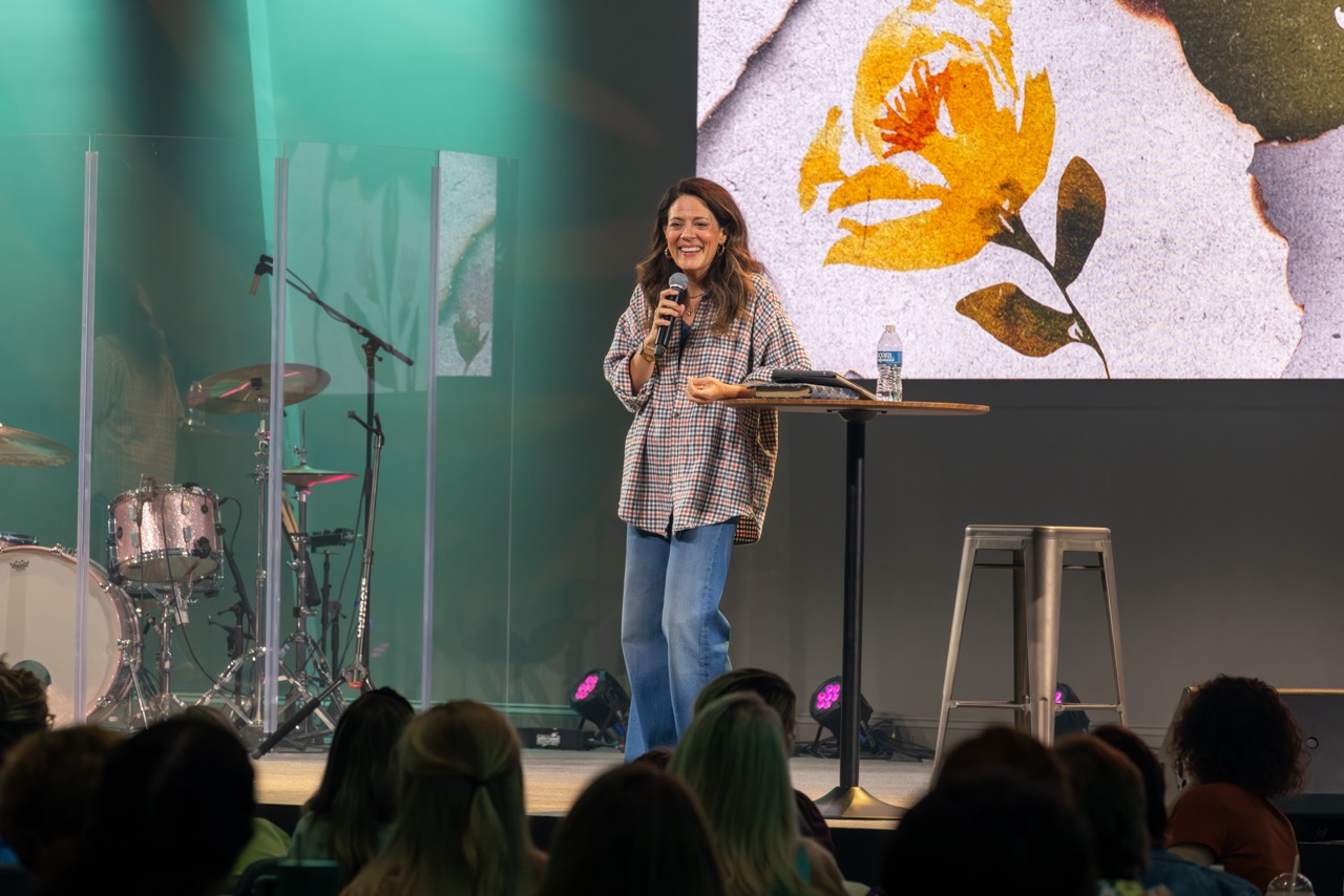 A woman speaking to the room at the Women's Conference