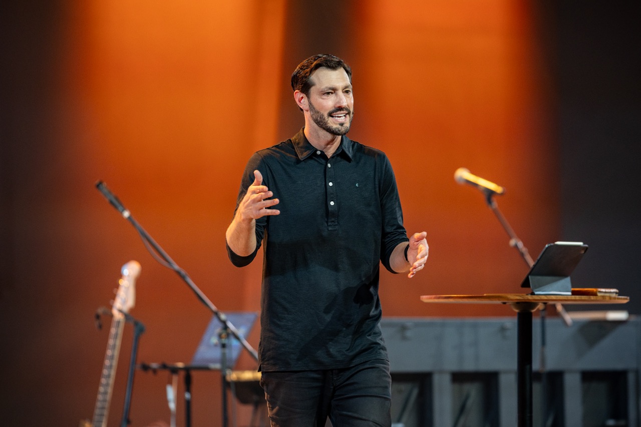 A man speaking to the room at the Men's Conference